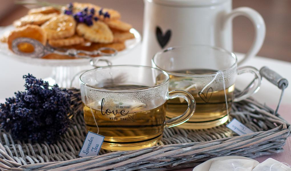 Lawendowa herbata w szklankach i bukiecik lawendy na tacy.