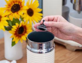 Dłoń trzymająca sprężynkę spieniacza do mleka Nespresso.
