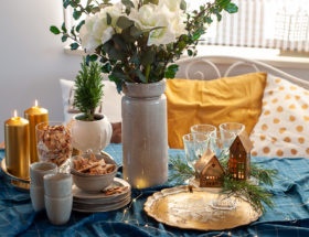 Świąteczny stół udekorowany w kolorze złota i granatu.