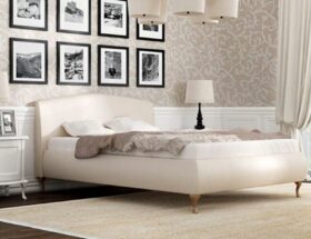 Kremowe tapicerowane łóżko w sypialni w stylu francuskim.